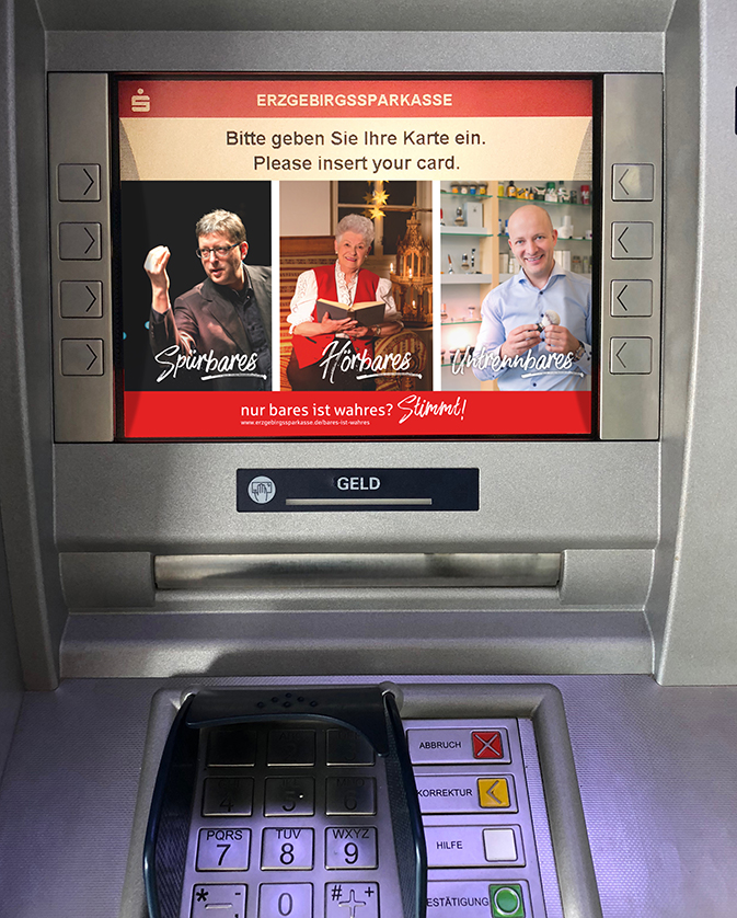 Geldautomat mit drei Kampagnemotiven auf dem Monitor